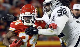 FILE - In this Dec. 1, 2019, file photo, Kansas City Chiefs running back Darwin Thompson (34) gets past Oakland Raiders defensive tackle P.J. Hall (92) during the second half of an NFL football game in Kansas City, Mo., The Minnesota Vikings have acquired Hall from the Raiders for a conditional seventh-round draft pick in 2021. Hall provides reinforcement for the interior for the Vikings after the opt-out by expected starter Michael Pierce. (AP Photo/Reed Hoffmann, File)