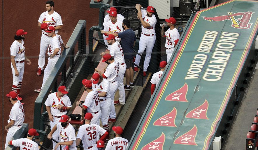 In this July 24, 2020, file photo, members of the St. Louis Cardinals wait to be introduced before the start of a baseball game against the Pittsburgh Pirates in St. Louis. The Cardinals 4-game series against the Detroit Tigers was postponed Monday, Aug. 3, 2020, after more Cardinals players and staff staffers test positive for COVD-19. The series was to have been played in Detroit from Tuesday through Thursday. (AP Photo/Jeff Roberson) ** FILE **