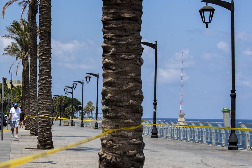 A man walks near a cordoned off area which is almost empty of residents and tourists, officially closed following the government&#x27;s measures to help stop the spread of the coronavirus, in Beirut, Lebanon, Monday, Aug. 3, 2020. (AP Photo/Hassan Ammar)