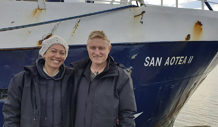 In this July 2020, photo supplied by Feeonaa and Neville Clifton, Neville and Feeonaa Clifton are pictured by the San Aotea II fishing boat in the Falkland Islands. The Cliftons, a honeymoon couple who were stranded on the remote Falkland Islands in March because of the coronavirus have managed to get home to New Zealand, Tuesday Aug. 4, 2020 by hitching a lift of more than 5,000 nautical miles (9,200 kilometers) on an Antarctic fishing boat. (Feeonaa/Neville Clifton via AP)