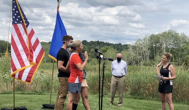 Wisconsin Supreme Court Justice Jill Karofsky is sworn in by fellow Justice Rebecca Dallet, right, as her children, Danny and Daphne, and former Gov. Jim Doyle look on. Karofsky took the oath Saturday, Aug. 1, 2020, in Basco, Wis., during a break in a 100-mile run. (Patrick Marley/Milwaukee Journal-Sentinel via AP)