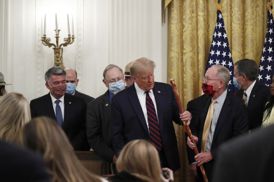 Sen. Lamar Alexander, R-Tenn., gives President Donald Trump a walking stick during a signing ceremony for H.R. 1957 – &quot;The Great American Outdoors Act,&quot; in the East Room of the White House, Tuesday, Aug. 4, 2020, in Washington. (AP Photo/Alex Brandon)