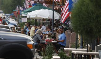 Diners eat outside a restaurant Tuesday, Aug. 4, 2020, in Grand Lake, Colo., during the coronavirus pandemic. (AP Photo/David Zalubowski)
