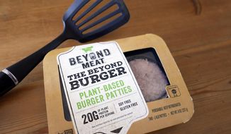 FILE - In this June 26, 2019, file photo, a package of meatless burgers by Beyond Meat are seen in Orlando, Fla. More people are throwing plant-based burgers on the grill this summer. Beyond Meat, which makes pea protein-based burgers and sausages, says its second-quarter revenue in 2020 jumped 69% to $113 million as more households tried its products. That far outpaced Wall Street’s forecast of $99 million. (AP Photo/John Raoux, File)