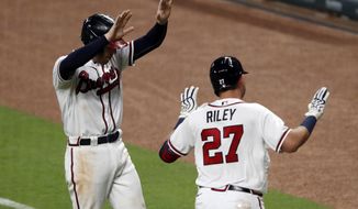 Atlanta Braves&#x27; Austin Riley (27) celebrates with teammate Freddie Freeman without contact after hitting a three-run home run in the fifth inning of a baseball game against the Toronto Blue JaysTuesday, Aug. 4, 2020, in Atlanta. (AP Photo/John Bazemore)