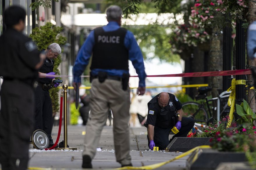 Chicago police investigate the scene where three people were shot, one of them fatally, in the Gold Coast neighborhood of the Chicago, Tuesday, Aug. 4, 2020. (Tyler LaRiviere/Chicago Sun-Times via AP)