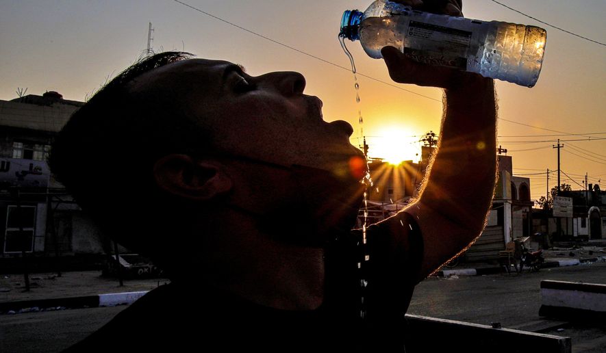 Laith Jabbar, a gas station worker drinks water in Basra, Iraq, Monday, July. 27, 2020. As temperatures soar to record levels this summer, Iraq&#x27;s power supply falls short of demand again, providing a spark for renewed anti-government protests. Amid a nationwide virus lockdown, homes are without electricity for hours in the blistering heat. (AP Photo/Nabil al-Jurani)