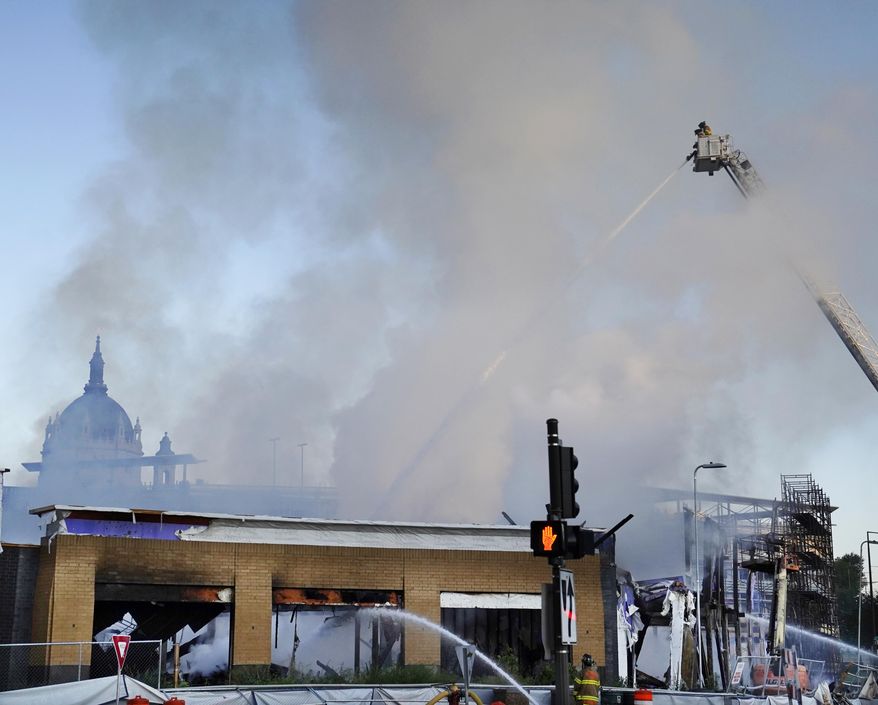 Firefighters battle a fire in downtown St. Paul, Minn., that has engulfed a building that was under construction on Tuesday, Aug. 4, 2020. There were no reports of injuries and there was no immediate word about the possible cause of the fire. (David Joles/Star Tribune via AP)