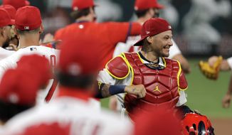 FILE - In this Friday, July 24, 2020, file photo, St. Louis Cardinals catcher Yadier Molina, right, celebrates a 5-4 win over the Pittsburgh Pirates in a baseball game in St. Louis.  Molina says he’s one of the players on his team who has tested positive for the coronavirus. The nine-time All-Star revealed his diagnosis Tuesday, Aug. 4, 2020, in a Spanish-language Instagram post. (AP Photo/Jeff Roberson, File)