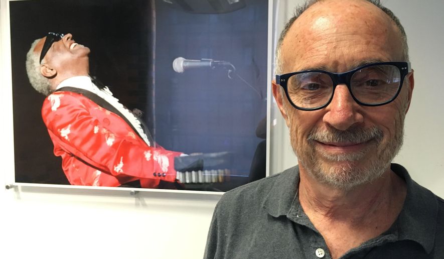FILE - In this June 18, 2018, file photo, Gregory Katz, acting London bureau chief for The Associated Press, poses for a photo backdropped by a photo of American pianist singer songwriter Ray Charles, at the AP's London office. Katz, an acclaimed correspondent for The AP whose career over four decades took him across the globe, died Monday, June 22, 2020. He had been ill in recent months and had contracted COVID-19. He was 67. (AP Photo/File)