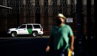 A Border Patrol vehicle sits near the border wall separating Mexicali, Mexico from Calexico, Calif., Tuesday, July 21, 2020, in Calexico. The city of 1 million just to the south brings tens of thousands of people daily to cross. Janette Angulo, Imperial County&#39;s public health director, estimates the population doubles during the day in winter, making the official count deceptively low. (AP Photo/Gregory Bull)