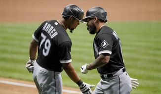 Chicago White Sox&#39;s Yoan Moncada is congratulated by Jose Abreu (79) after hitting a home run during the ninth inning of a baseball game against the Milwaukee Brewers Monday, Aug. 3, 2020, in Milwaukee. (AP Photo/Morry Gash)