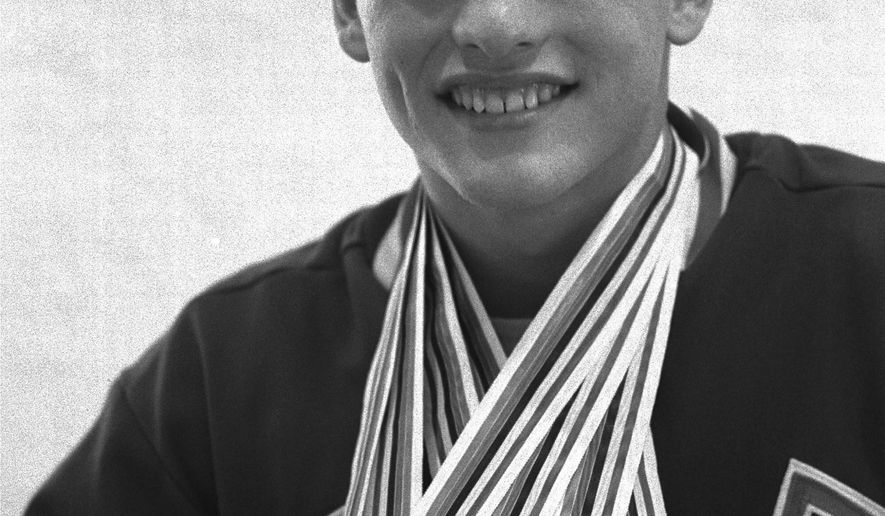 FILE - In this Oct. 18, 1964, file photo, Don Schollander of Lake Oswego, Ore., poses with the four gold medals he won during Olympic swimming competitions in Tokyo. Schollander won the gold medals for the 100 and 400 meters freestyle, and swam legs of the winning 400-meter medley and 800-meter freestyle relays. (AP Photo/File)
