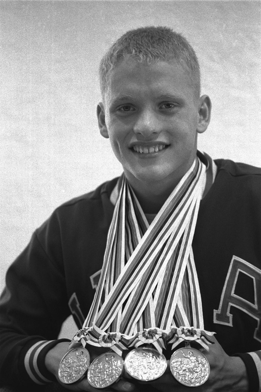 FILE - In this Oct. 18, 1964, file photo, Don Schollander of Lake Oswego, Ore., poses with the four gold medals he won during Olympic swimming competitions in Tokyo. Schollander won the gold medals for the 100 and 400 meters freestyle, and swam legs of the winning 400-meter medley and 800-meter freestyle relays. (AP Photo/File)