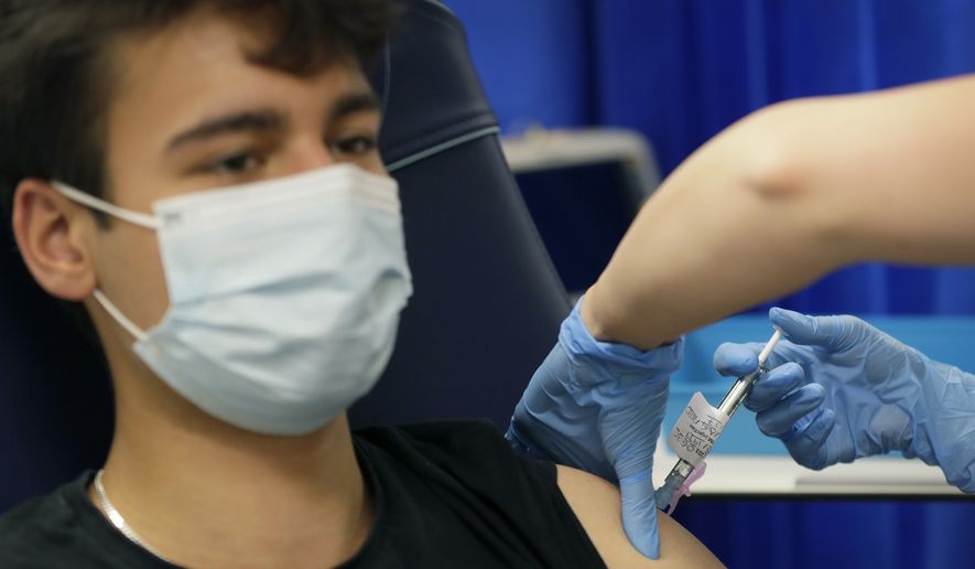 Volunteer Yash is injected with the vaccine as part of an Imperial College vaccine trial, at a clinic in London, Wednesday, Aug. 5, 2020. Scientists at Imperial College London are immunizing hundreds of people with an experimental coronavirus vaccine in an early trial after seeing no worrying safety problems in a small number vaccinated so far. (AP Photo/Kirsty Wigglesworth)