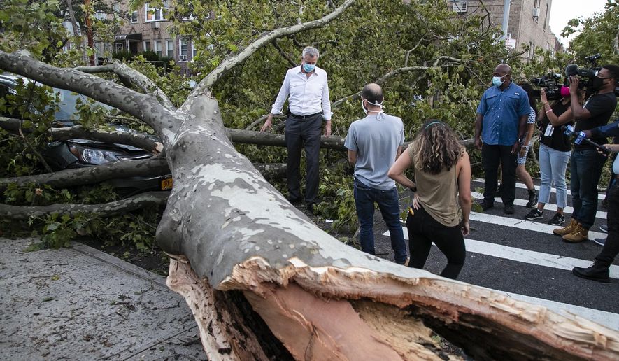 New York City Mayor Bill de Blasio talks with residents about damage from Tropical Storm Isaias, Tuesday, Aug. 4, 2020, in the Queens borough of New York. (AP Photo/Frank Franklin II)