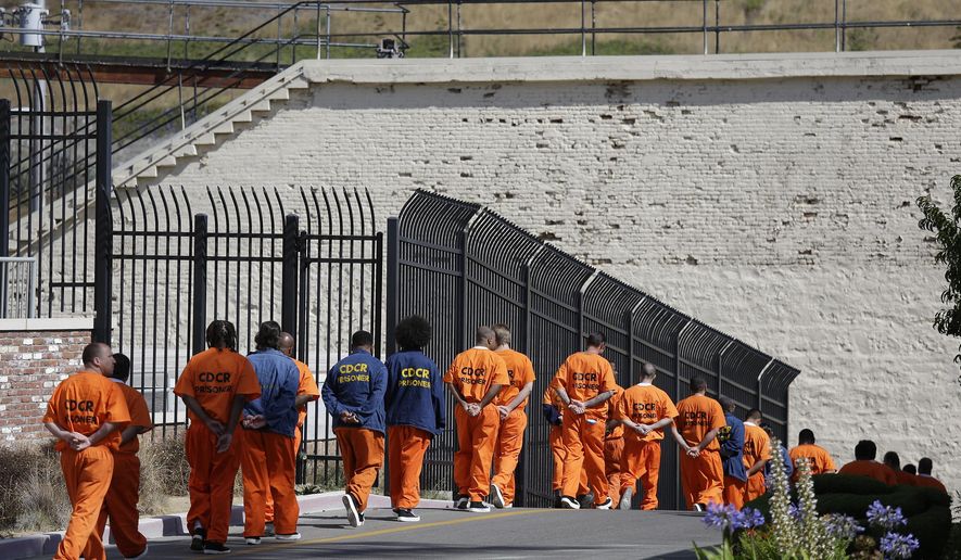 FILE - In this Aug. 16, 2016, file photo, a row of general population inmates walk in a line at San Quentin State Prison in San Quentin, Calif. California state prison officials say in a July 27, 2020, court filing that as many as 17,600 inmates are eligible for release due to the coronavirus, 70% more than previously estimated and a total that victims and police say includes dangerous criminals who should stay locked up. (AP Photo/Eric Risberg, File)