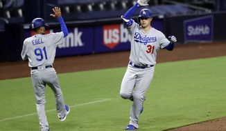 Los Angeles Dodgers&#x27; Joc Pederson, right, reacts with third base coach Dino Abel after hitting a three-run home run during the sixth inning of a baseball game against the San Diego Padres, Wednesday, Aug. 5, 2020, in San Diego. (AP Photo/Gregory Bull)