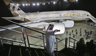 FILE - In this Dec. 18, 2014 file photo, an Emirati man takes a selfie in front of a new Etihad Airways A380 in Abu Dhabi, United Arab Emirates. Abu Dhabi-based Etihad Airways said Thursday, Aug. 6, 2020, that its core operating losses amounted to $758 million for the first half of the year, driven by a nearly 40% drop in revenue due in part to the impact of the coronavirus pandemic. (AP Photo/Kamran Jebreili, File)