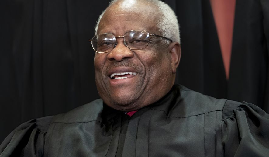 In this Nov. 30, 2018, file photo, Supreme Court Associate Justice Clarence Thomas, appointed by President George H. W. Bush, sits with fellow Supreme Court justices for a group portrait at the Supreme Court Building in Washington. Thomas has never been afraid to turn right when his colleagues turn left, or in any direction really as long as there’s a place to plug in his 40-foot refitted tour bus. (AP Photo/J. Scott Applewhite, File)