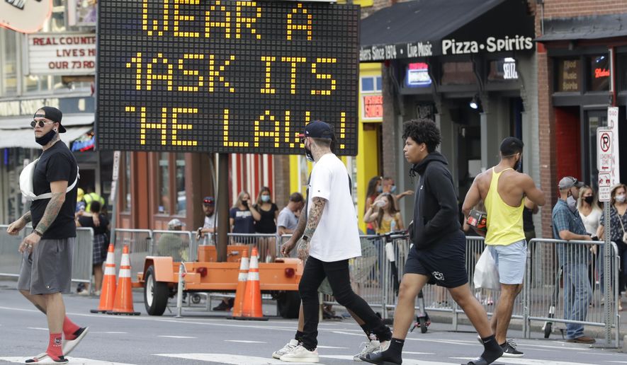 A sign encouraging the wearing of masks stands in downtown Nashville, Tenn., Wednesday, Aug. 5, 2020. The wearing of face coverings is required in most public indoor and outdoor situations in Nashville due to an increase of COVID-19 cases. (AP Photo/Mark Humphrey)