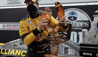 Driver Brad Keselowski holds a giant lobster to celebrate his victory in a NASCAR Cup Series auto race, Sunday, Aug. 2, 2020, at the New Hampshire Motor Speedway in Loudon, N.H. (AP Photo/Charles Krupa)
