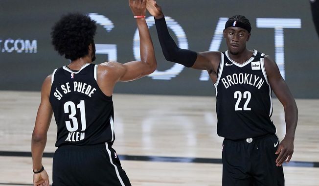 Brooklyn Nets&#x27; Jarrett Allen (31) and Caris LeVert (22) react after a play against the Sacramento Kings during the first half of an NBA basketball game Friday, Aug. 7, 2020 in Lake Buena Vista, Fla. (AP Photo/Ashley Landis, Pool)
