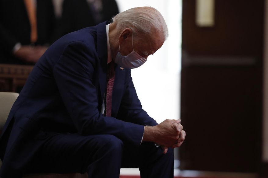 In this  June 1, 2020, file photo, Democratic presidential candidate, former Vice President Joe Biden bows his head in prayer as he visits Bethel AME Church in Wilmington, Del. Photos in a campaign ad for President Donald Trump show that former Vice President Biden is “alone, hiding, diminished.” The ad blurs details that show Biden is praying in a church. The ad was tweeted by @TeamTrump on Wednesday, Aug. 5, 2020. (AP Photo/Andrew Harnik, File)