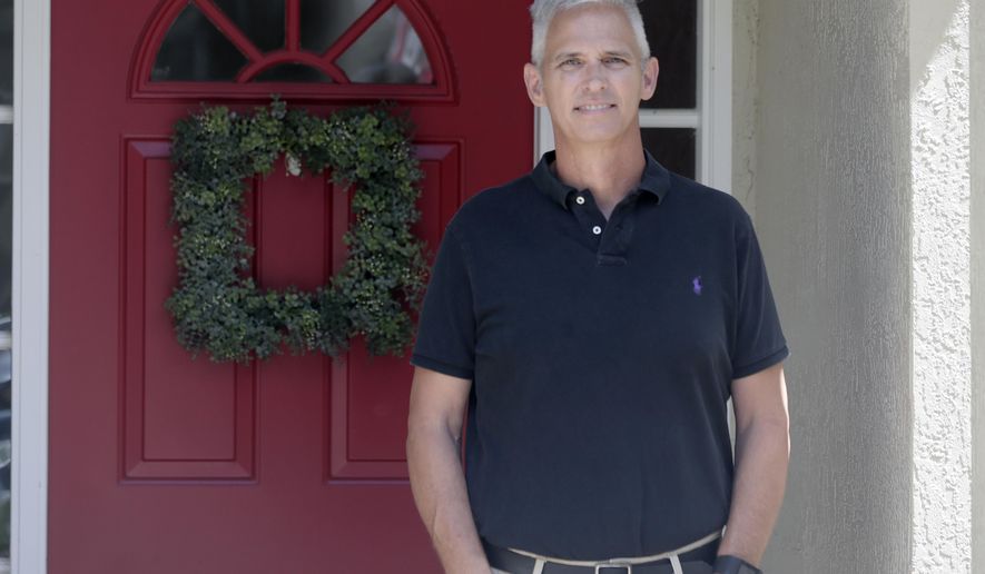 Bob Garick stands by the entrance to his home Wednesday, Aug. 5, 2020, in Oviedo, Fla. Garick was looking forward to being a field supervisor during the door-knocking phase of the 2020 census, but as the number of new coronavirus cases in Florida shot up last month, he changed his mind and decided not to take the job. The loss of these so-called door-knockers - formally known as enumerators - is happening just when the agency faces newly tightened deadlines to reach the hardest to count communities, including minorities and immigrants. (AP Photo/John Raoux)