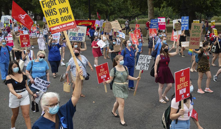National Health Service (NHS) workers march from St. James' Park to Downing Street, London, Saturday Aug. 8, 2020, as part of a national protest over pay. Nationwide protests on Saturday are calling for government to address what they claim is many years of reduced wages, and are calling for a voice in plans for public sector pay increases. (Dominic Lipinski/PA via AP)