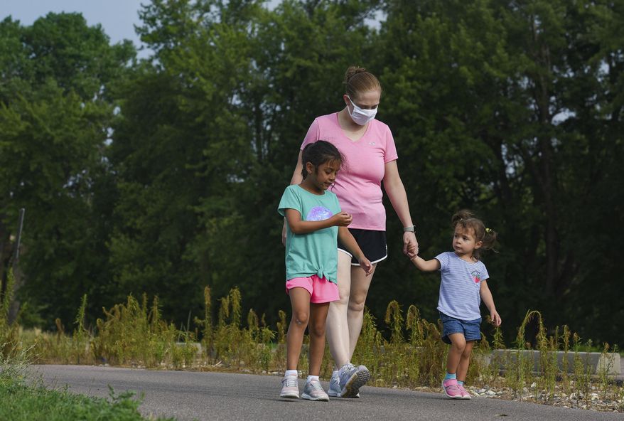 Mollie Sanchez goes for a walk with her daughters, Liliana (6) and Zoie (2) on Wednesday, July 29, 2020 at Yankton Trail Park in Sioux Falls, S.D. Sanchez won the mayor's fitness challenge to bike, walk or run 100 miles in 100 days. (Erin Bormett /The Argus Leader via AP)