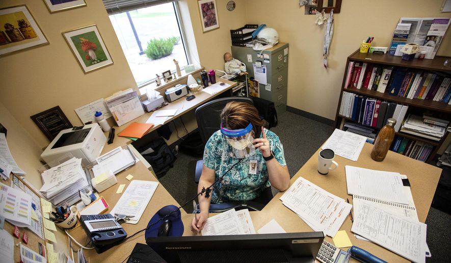 Public Health Nurse Joli Carr asks a series of questions to someone who has tested positive for the coronavirus while conducting a contact tracing phone call on July 24, 2020, at Campbell County Public Health in Gillette, Wyo. (Mike Moore/Gillette News Record via AP)