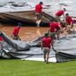 Grounds crew tries to untangle the tarp as they attempt to cover the baseball diamond from a heavy downpour delaying the baseball game during the sixth inning of a baseball game between the Washington Nationals and the Baltimore Orioles in Washington, Sunday, Aug. 9, 2020. (AP Photo/Manuel Balce Ceneta)