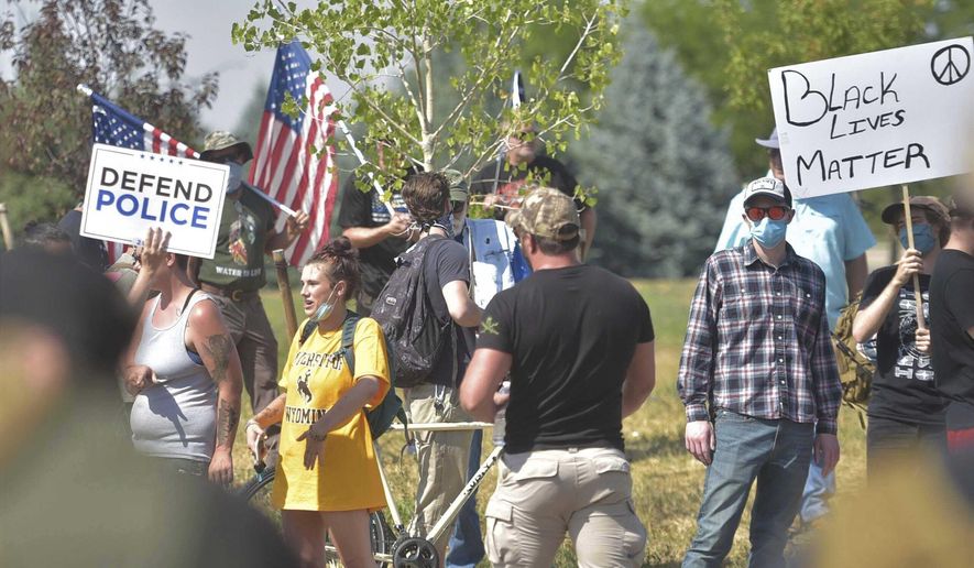 People participate in a defend the police rally outside the Fort Collins Police Services building on Saturday, Aug. 8, 2020, in Fort Collins, Colo. Three people were arrested and another cited after fights broke out at a Colorado pro-police rally that attracted counter protesters, authorities said. The “Back the Blue” rally drew hundreds of people outside the Fort Collins police department Saturday afternoon. (Kevin Lytle/Fort Collins Coloradoan via AP)