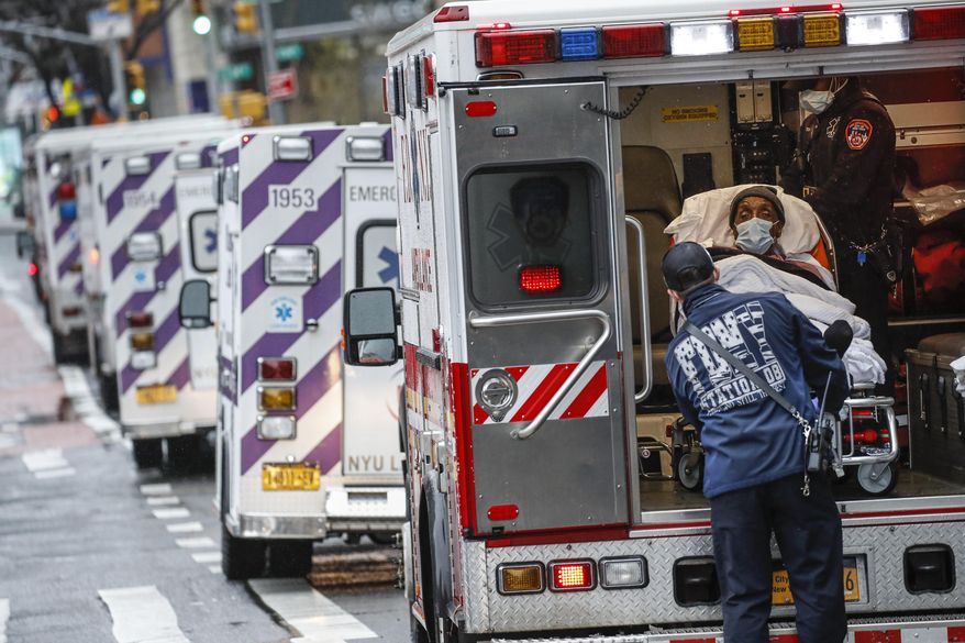 FILE - In this Monday, April 13, 2020, file photo, a patient arrives in an ambulance cared for by medical workers wearing personal protective equipment due to COVID-19 coronavirus concerns outside NYU Langone Medical Center in New York. America's failure so far to contain the spread of the coronavirus as it moves across the country has been met with astonishment and alarm on both sides of the Atlantic. (AP Photo/John Minchillo, File)