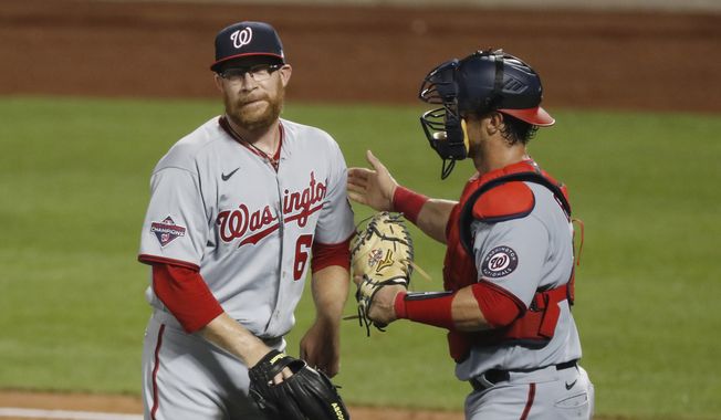 Washington Nationals catcher Yan Gomes, right, congratulates relief pitcher Sean Doolittle after the Nationals defeated the New York Mets 16-4 in a baseball game, Monday, Aug. 10, 2020, in New York. (AP Photo/Kathy Willens) ** FILE **
