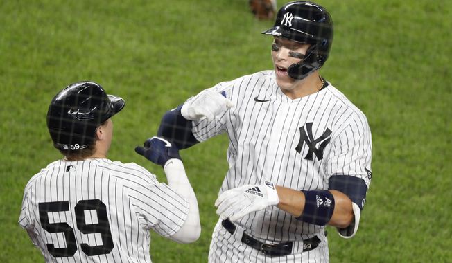 New York Yankees Aaron Judge, right, celebrates with the Yankees Luke Voit (59) after hitting a solo home run during the fifth inning of a baseball game against the Atlanta Braves, Tuesday, Aug. 11, 2020, in New York. (AP Photo/Kathy Willens)