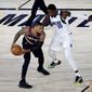 Portland Trail Blazers guard Damian Lillard holds the ball while defended by Dallas Mavericks forward Dorian Finney-Smith (10) during the second half of an NBA basketball game Tuesday, Aug. 11, 2020, in Lake Buena Vista, Fla. (Kim Klement/Pool Photo via AP)