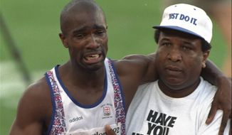 In this Monday, Aug. 3, 1992, file photo, Britain&#39;s Derek Redmond grimaces as he is helped from the track by his father, Jim Redmond, after an injury during the semifinals of the Men&#39;s 400-meter race at the Summer Olympics Games in Barcelona (AP Photo/Denis Paquin, File)