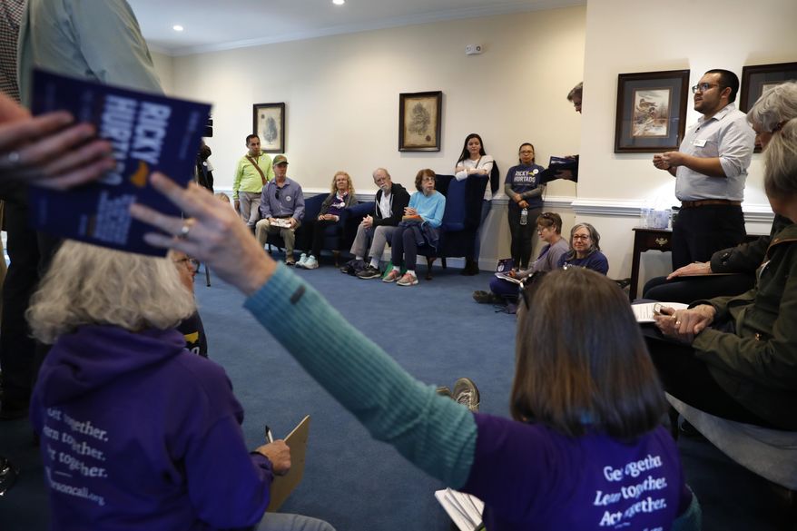 Ricky Hurtado, a Democratic candidate for the North Carolina state house, right, talks to volunteers before they head out to canvass voters, in Mebane, N.C., Sunday, March 8, 2020. (AP Photo/Jacquelyn Martin)