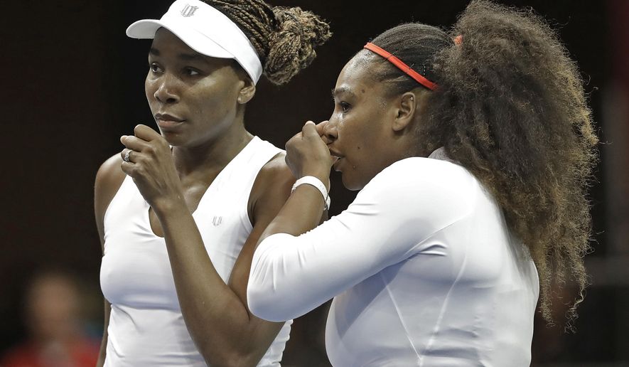 FILE - In this Sunday, Feb. 11, 2018, file photo, USA&#39;s Venus Williams, left, and Serena Williams, right, talk between points in their doubles match against Netherlands&#39; Leslie Herkhove and Demi Schuurs in the first round of Fed Cup tennis competition in Asheville, N.C. The siblings meet each other for the 31st time when they take the court at a WTA tournament in Kentucky on Thursday, Aug. 13, 2020. (AP Photo/Chuck Burton, File)