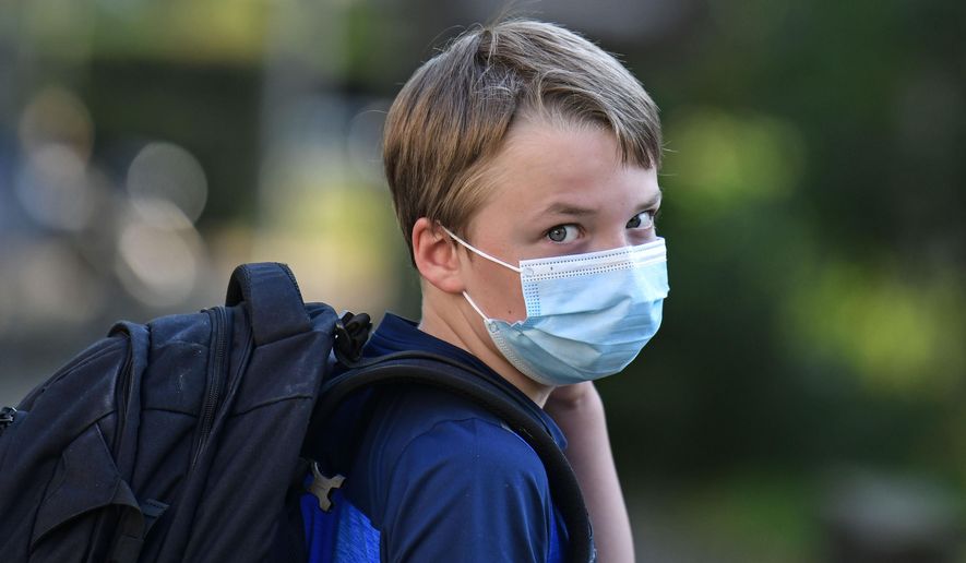 Pupil Moritz is on his way to the first day at his new school in Gelsenkirchen, Germany, Wednesday, Aug. 12, 2020. Students in North Rhine-Westphalia will have to wear face masks at all times due to the coronavirus pandemic as they return to school this Wednesday. (AP Photo/Martin Meissner)
