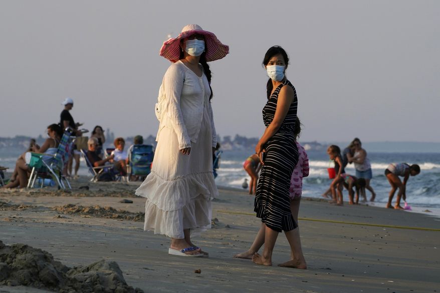 Women wear masks to help prevent the spread of coronavirus at the end of a beach day, Tuesday, Aug. 11, 2020, in Ogunquit, Maine. (AP Photo/Robert F. Bukaty)