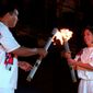 FILE - In this July 19, 1996, file photo, American swimmer Janet Evans passes the Olympic flame to Muhammad Ali during the 1996 Summer Olympic Games Opening Ceremony in Atlanta. (AP Photo/Michael Probst, File)