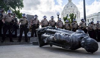 State troopers line up around a fallen statue of Christopher Columbus at the Minnesota State Capitol in St. Paul, Minn., on Wednesday, June 10, 2020. (Evan Frost/Minnesota Public Radio via AP)