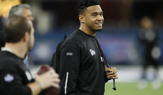 FILE - In this Feb. 27, 2020, file photo, Alabama quarterback Tua Tagovailoa watches a drill at the NFL football scouting combine in Indianapolis. Tagovailoa is happy to keep a low profile befitting his rookie status, even though he’s widely hailed as the Miami Dolphins’ future franchise quarterback. (AP Photo/Charlie Neibergall, File)