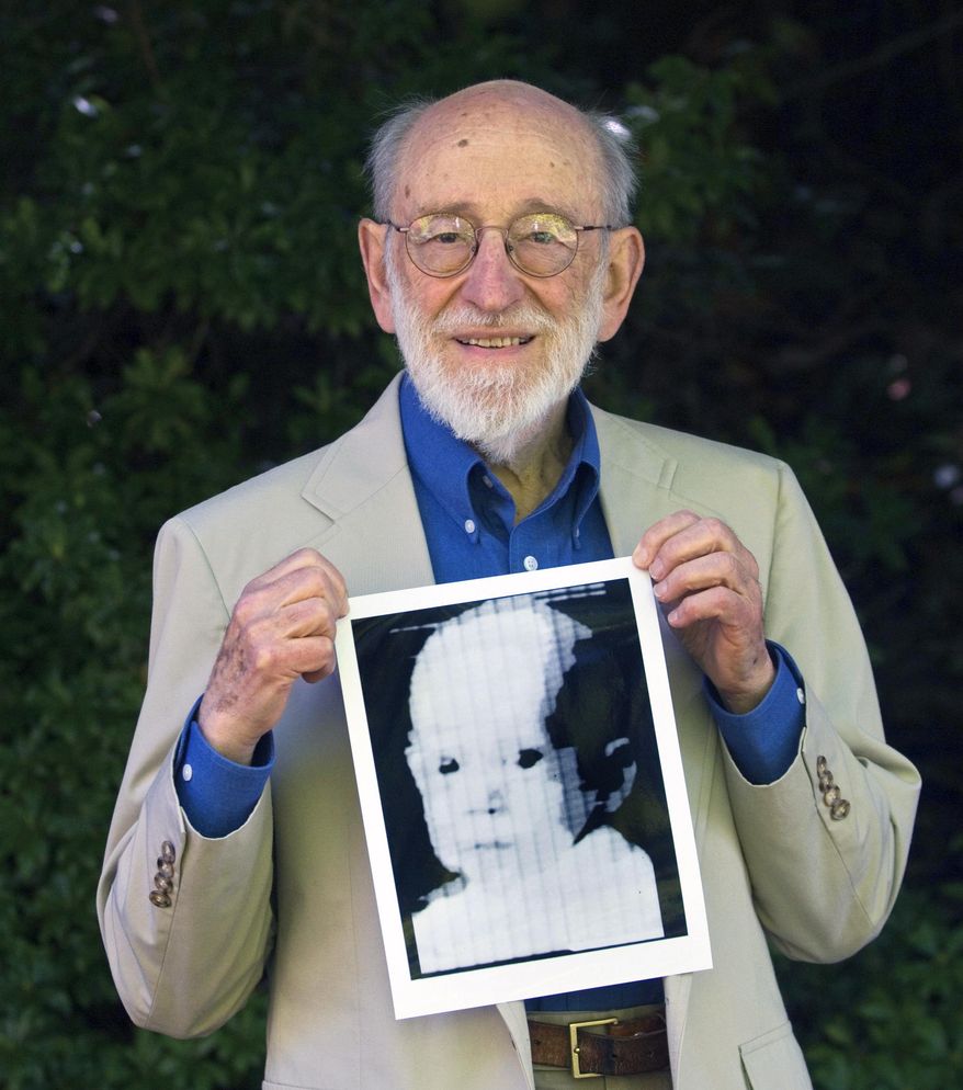 FILE - In this 2007 file photo ,Russell Kirsch holds the image of his son, Walden, that was scanned into the world's first digital scanner in 1957. Russell Kirsch, a computer scientist credited with inventing the pixel and scanning the world’s first digital photograph, died Aug. 11, 2020 at his home in Portland, Oregon, The Oregonian reported. He was 91. (Jamie Francis/The Oregonian via AP, File)