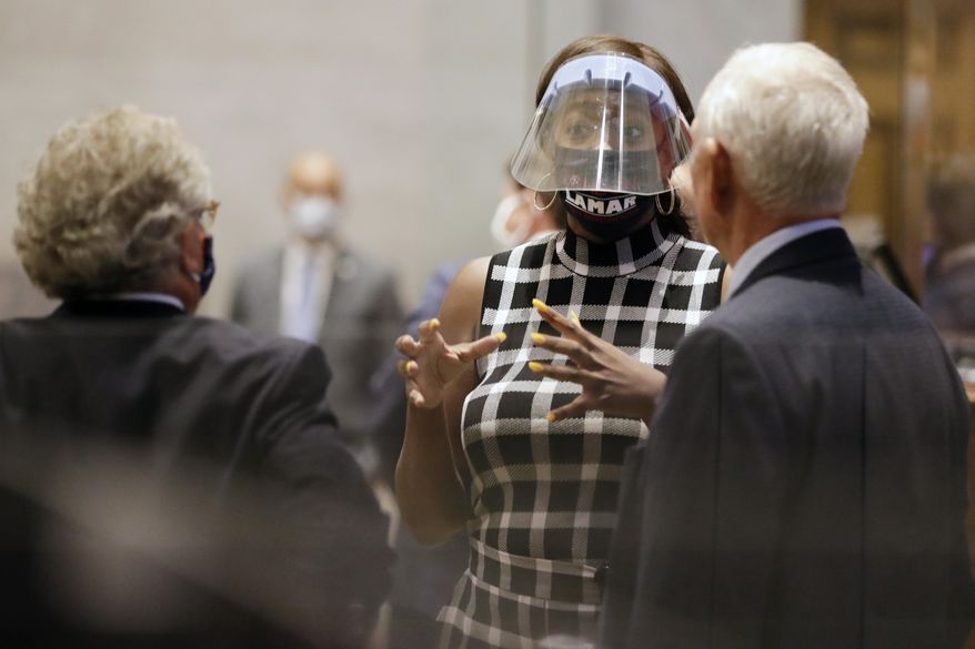 Rep. London Lamar, center, D-Memphis, talks with other House members during a special session Monday, Aug. 10, 2020, in Nashville, Tenn. The special session was called by Tennessee Gov. Bill Lee to pass liability reforms to protect businesses from lawsuits prompted by reopening after the coronavirus quarantine. (AP Photo/Mark Humphrey)