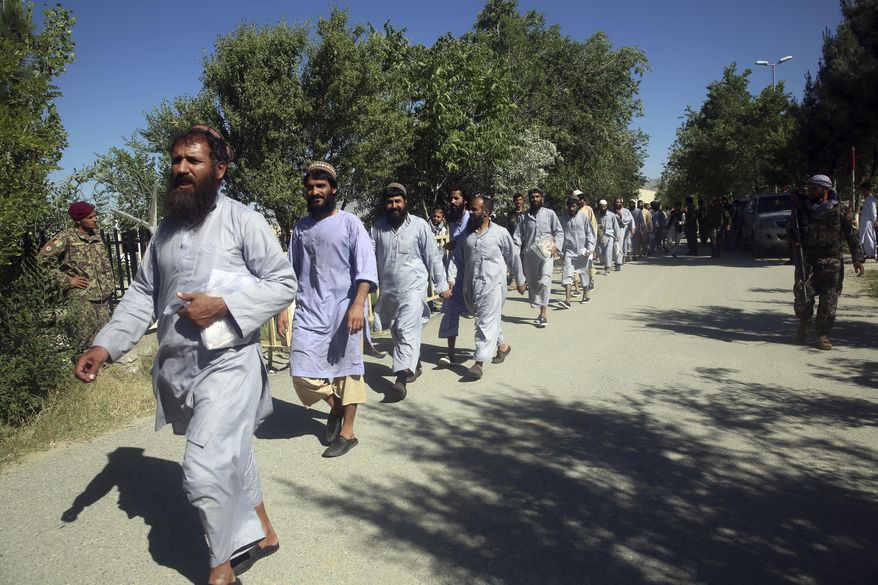 FILE - In this May 26, 2020, file photo, prisoners are released from Bagram Prison in Parwan province, Afghanistan. The Afghan government freed hundreds of prisoners, its single largest prisoner release since the U.S. and the Taliban signed a peace deal earlier this year that spells out an exchange of detainees between the warring sides. Afghanistan has released the first 86 of a final 400 Taliban prisoners, paving the way for negotiations between the warring sides in Afghanistan’s protracted conflict, the government said Friday, Aug. 14, 2020. (AP Photo/ Rahmat Gul, File)