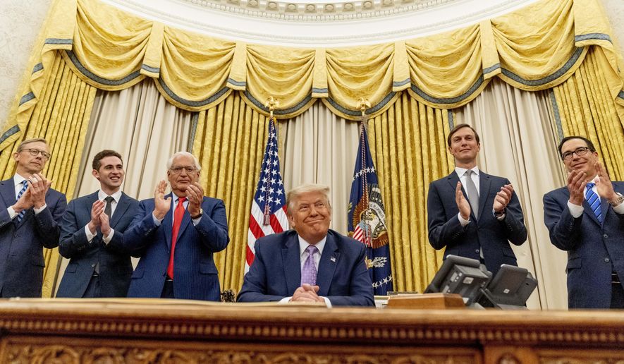 President Donald Trump, accompanied by From left, U.S. special envoy for Iran Brian Hook, Avraham Berkowitz, Assistant to the President and Special Representative for International Negotiations, U.S. Ambassador to Israel David Friedman, President Donald Trump&#x27;s White House senior adviser Jared Kushner, and Treasury Secretary Steven Mnuchin, smiles in the Oval Office at the White House, Wednesday, Aug. 12, 2020, in Washington. Trump said on Thursday that the United Arab Emirates and Israel have agreed to establish full diplomatic ties as part of a deal to halt the annexation of occupied land sought by the Palestinians for their future state. (AP Photo/Andrew Harnik)